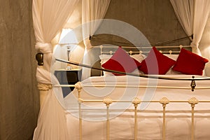 Hotel room with four-poster bed with white and red pillow
