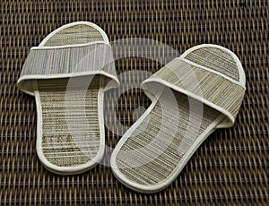 Hotel room slippers on rattan background
