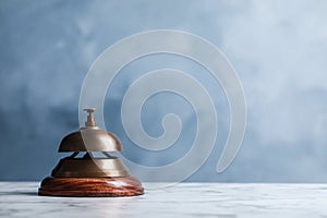 Hotel service bell on table against background. Space for text