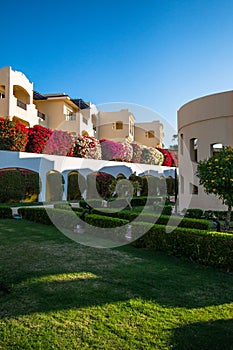 Hotel suites exterior with palms, garden and blue sky