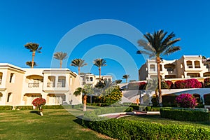Hotel suites exterior with palms, garden and blue sky photo
