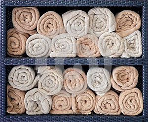 Hotel towels rolled in shelf.