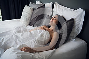 Hotel, travel and happiness concept - beautiful woman sleeping in bed