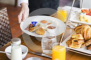 Hotel waitress serving food on the table