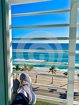 Hotel window beach view feet resting Fort Lauderdale Florida