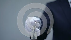 Hotel word on keychain in receptionist hand, room reservation, luxury services