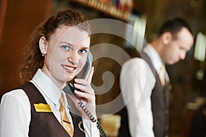 Hotel worker with phone on reception