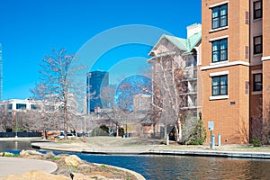 Hotels, buildings along Bricktown canal with downtown Oklahoma City skyline background, riverside restaurants, tourist attractions photo