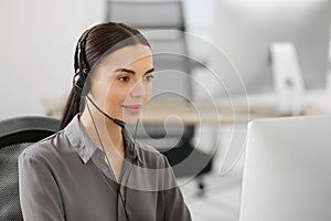 Hotline operator with headset working on computer in office