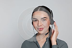 Hotline operator with modern headset on light grey background. Customer support