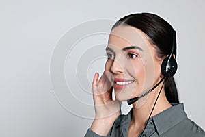 Hotline operator with modern headset on light grey background, space for text. Customer support