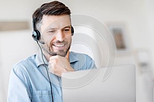 Hotline Support Service. Male call center operator in headset working with laptop