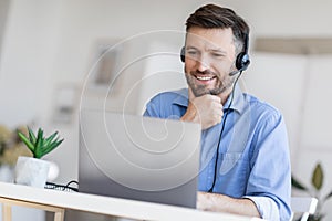 Hotline Support Service. Male call center operator in headset working with laptop