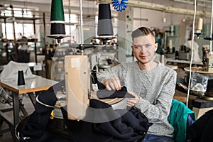 hoto of a young man working with linking machine for knitting in textile industry