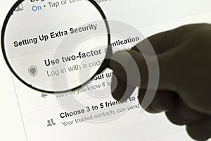 Hand holding a magnifying glass and magnifying the word setting up extra security