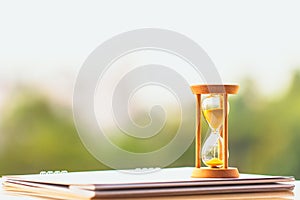 Hour glass on calendar concept for time slipping away for important appointment date.