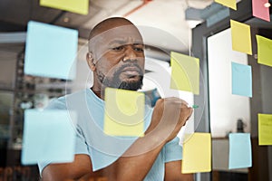 An hour of planning can save you 10 hours of doing. a businesswoman brainstorming with sticky notes on a glass screen.