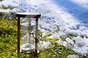 Hourglass as a symbol of changing of the seasons. Spring is coming photo