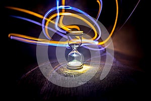 Hourglass as time passing concept for business deadline, urgency and running out of time. Sandglass, egg timer on dark background