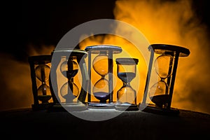 Hourglass as time passing concept for business deadline, urgency and running out of time. Sandglass, egg timer on dark background