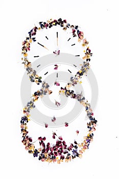 Hourglass of burnt matches and flowers on a white background.