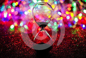 Hourglass with christmas lights and red glowy carpet as background