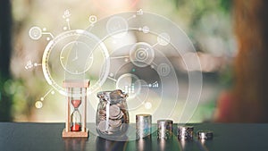 The hourglass, the coin, and the glass jar, all on the table,time management concepts for saving money,Finance and Investment,