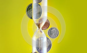 Hourglass with coins in the background