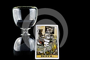 Hourglass with Death Tarot Card Isolated on a Black Background