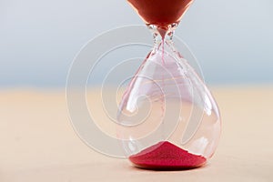 Hourglass with flowing sand on table. Time management