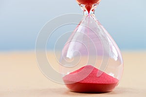 Hourglass with flowing sand on table. Time management