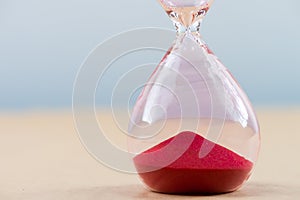 Hourglass with flowing sand on table. Time management