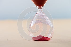 Hourglass with flowing sand on table. Time management