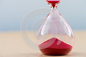 Hourglass with flowing sand on table. Time management