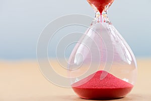 Hourglass with flowing sand on table. Time management