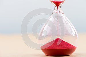 Hourglass with flowing sand on table. Time management