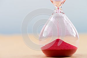 Hourglass with flowing sand on table. Time management