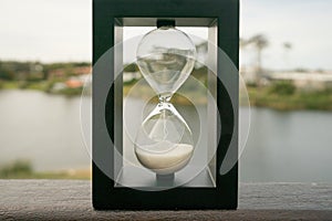 Hourglass with lake in the background photo