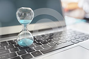 Hourglass on laptop computer concept for time management