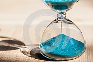 An hourglass measuring the passing time in a countdown to a deadline