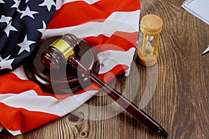 Hourglass measuring the US judge legal office with judge's gavel on American flag table