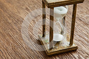 Hourglass on the Oak table as time passing concept for business