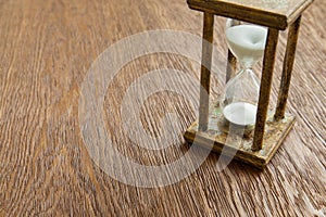 Hourglass on the Oak table as time passing concept for business