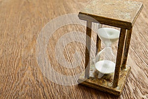 Hourglass on the Oak table as time passing concept for business