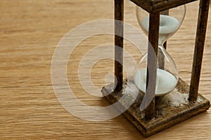 Hourglass on the Oak table as time passing concept for business