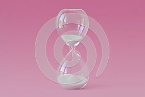 Hourglass on pink background - Concept of health, fertility and biological clock in women