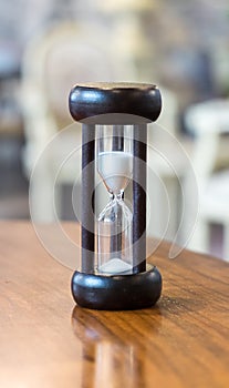 Hourglass or Sand Clock as Time Passing Concept for Business Deadline, Urgency and Running Out of Time. Black Wooden Sand Clock