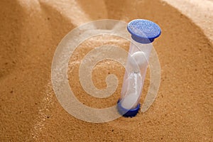 Hourglass on a sand dune beach. concept passage of time
