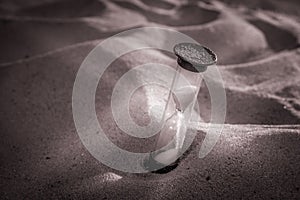 Hourglass on a sand dune beach. concept passage of time