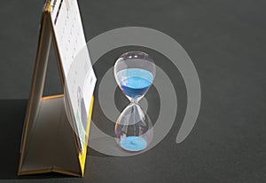 Hourglass sand next to calendar